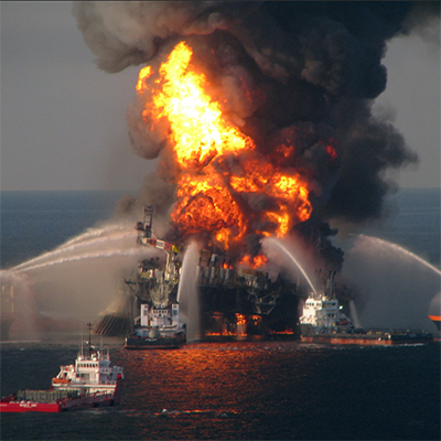 Several fire-rescue boats spray water on an oil rig that is on fire 
